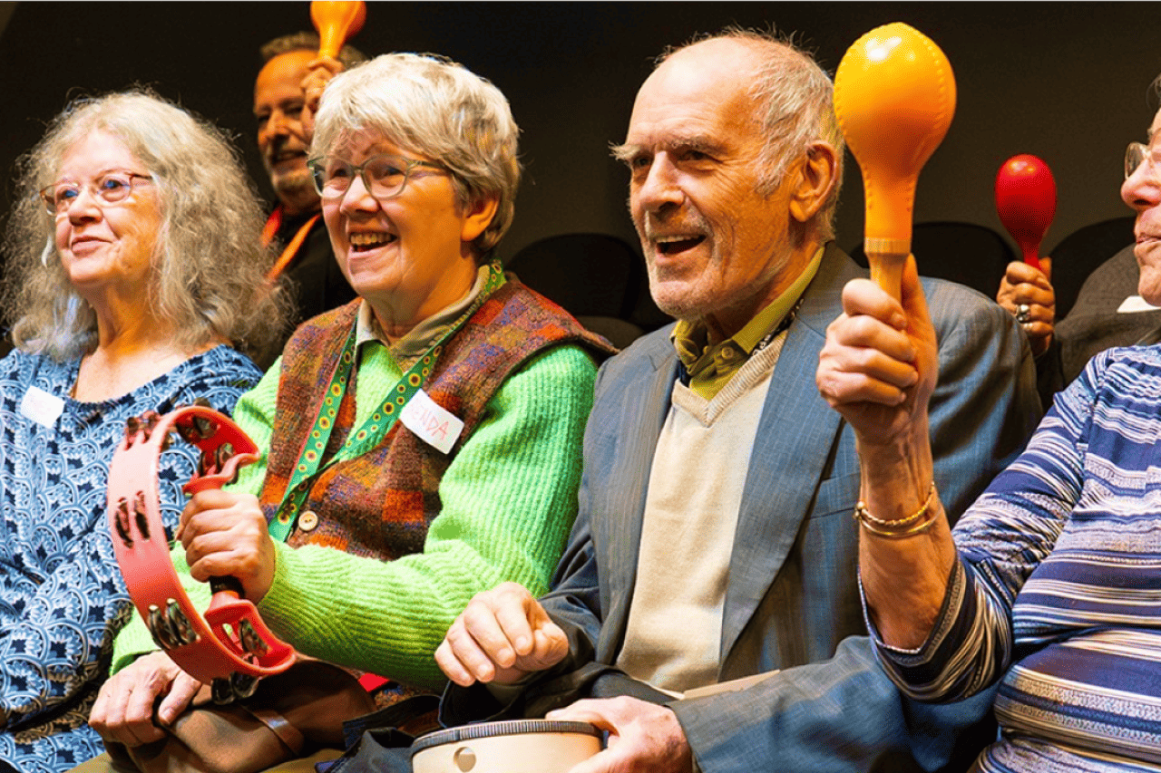 A zoomed in photo of people playing maracas and singing together
