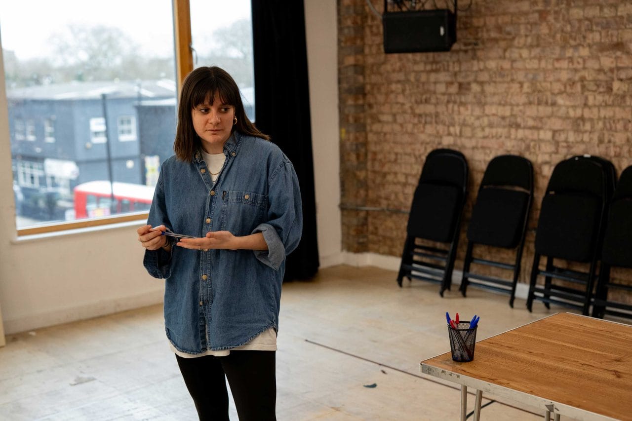 A woman in jeans shirt rehearsing a play in the Morris Space