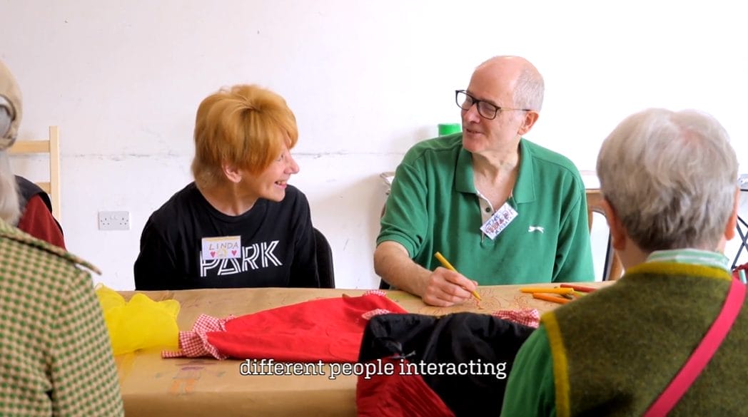Two people sit at a table chatting.