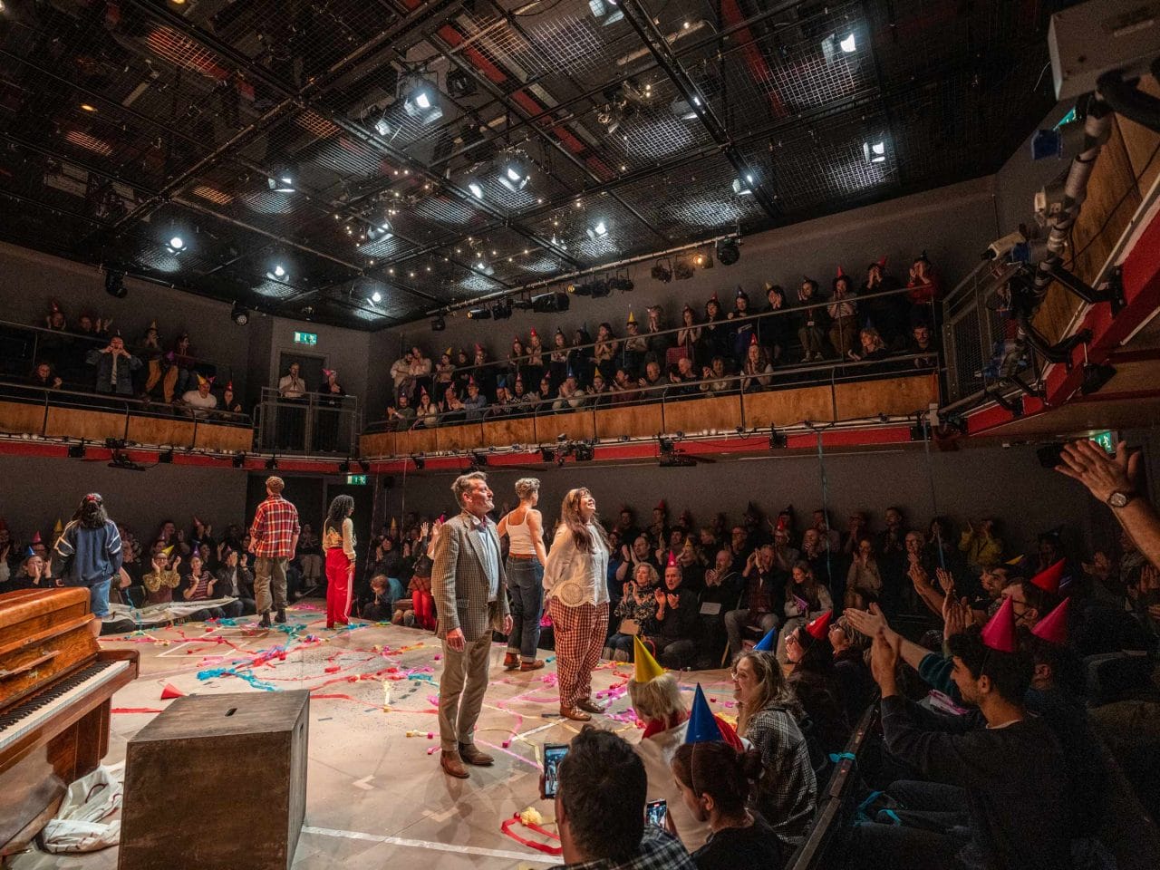 A full audience in Park 200 cheering and clapping as the cast look up about to bow.