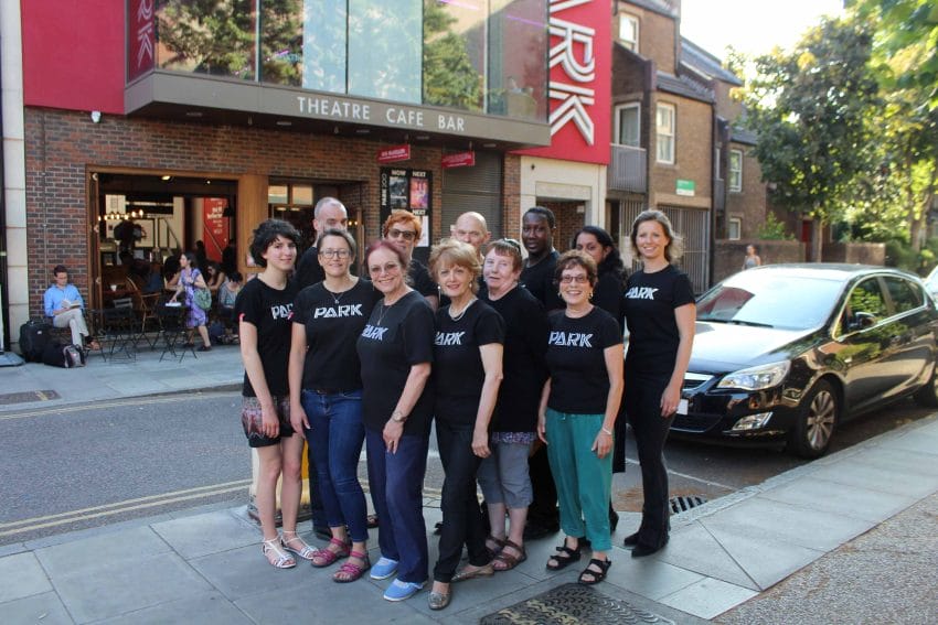 A group photo of volunteer ushers standing outside Park Theatre wearing matching black shirts