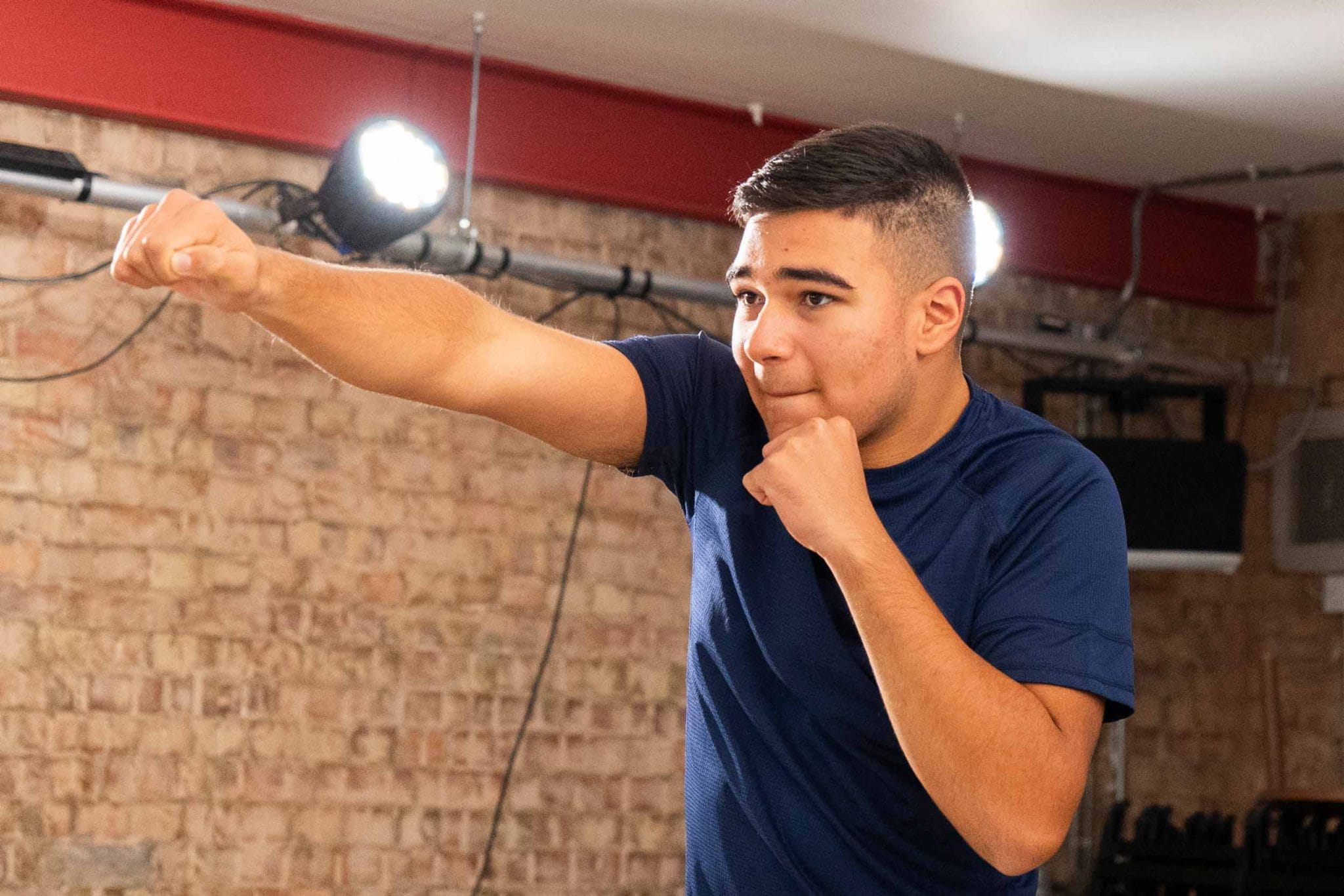 Photo of a boy in a blue shirt punching the air