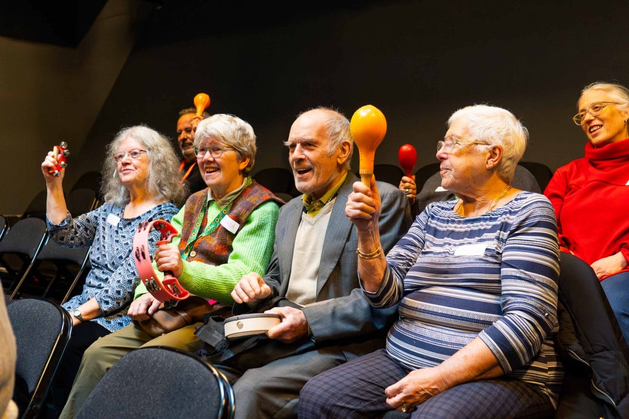 Group of people playing maracas and singing together